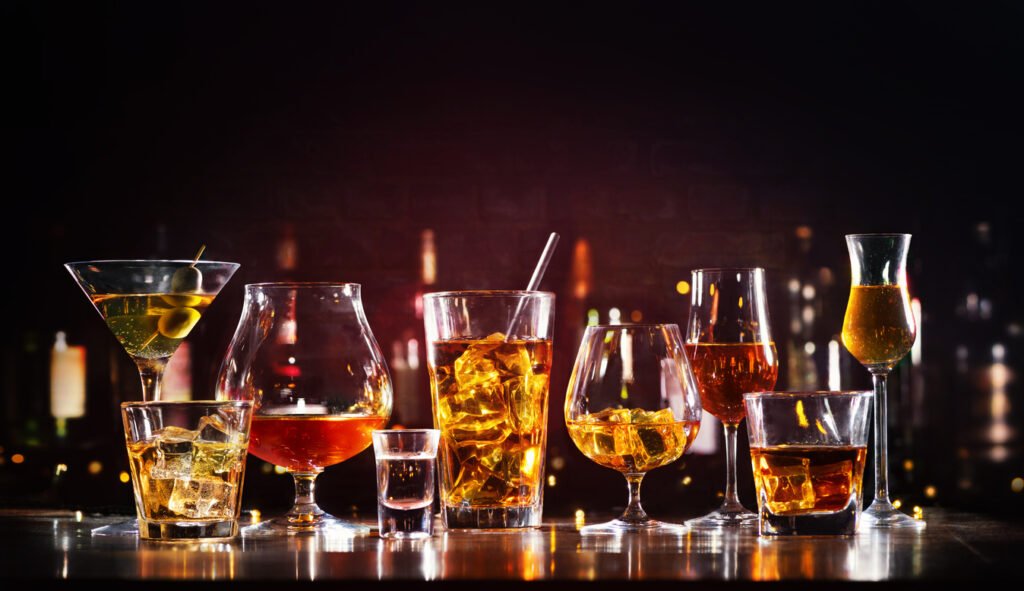 Assortment of hard strong alcoholic drinks and spirits in glasses on bar counter
